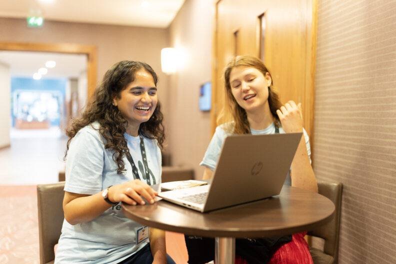 Images shows two women looking at a laptop